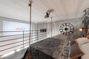 una camera con un letto e un orologio a muro di The Loft Polignano a Polignano a Mare