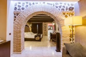 a room with a brick archway with a bed in it at Pintor El Greco in Toledo