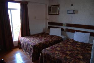 a hotel room with two beds and a window at Hotel Tankah Cancun in Cancún