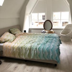 a bedroom with a bed and a mirror and two windows at LUXE TOPLOCATIE! Monument hartje centrum Dordrecht, 2 badkamers, 2 keukens, tuintje (10 personen) in Dordrecht