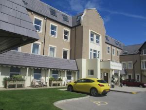 a yellow car parked in front of a building at Beaches Chalets in Prestatyn