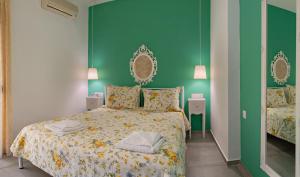 a bedroom with a bed and a green wall at The Village Apartments in Plakias