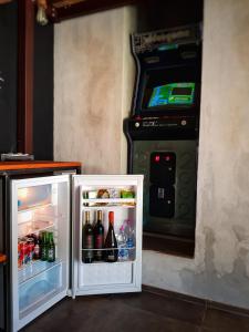 una macchina per videogiochi, seduta accanto a un frigorifero di The Loft Polignano a Polignano a Mare