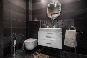 a bathroom with a sink and a toilet and a mirror at Cosy Luxury Flat in the Centrum- 90sqm - 3 rooms. in Varna City