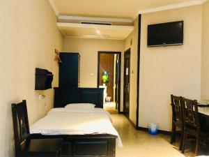 a bedroom with a bed and a flat screen tv at Xi'an Hantang House in Xi'an