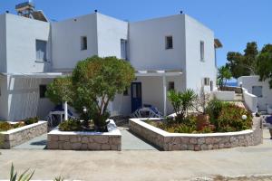 a white house with trees in front of it at Paleochori Studios in Paliochori