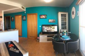 a living room with blue walls and a table at Apartamento El Barco 1 linea PLAYA, PARKING, WIFI in Torrox Costa