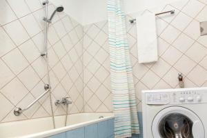 uma casa de banho com uma máquina de lavar roupa e uma banheira em Pension Sacher - Apartments am Stephansplatz em Viena