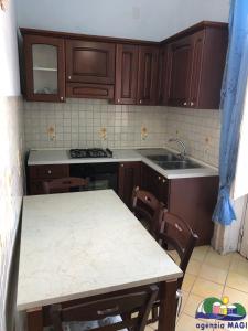 a kitchen with wooden cabinets and a table with chairs at Magi - Ulivo in Ponza