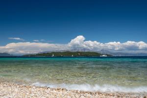 a beach with the ocean and mountains in the background at Sivros Stone Cottages in Sívros