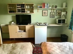 1 dormitorio con escritorio, microondas y TV en B&B Ishoej Private bath en Ishøj
