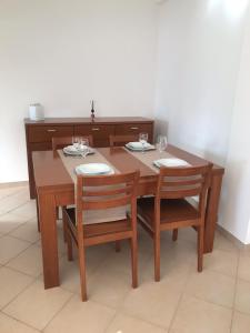 ヴィラモウラにあるsol nascenteの木製テーブルと椅子(皿、ワイングラス付)