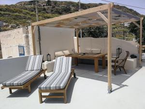 a patio with a wooden table and chairs on a roof at Katsinaros House in Emporio Santorini