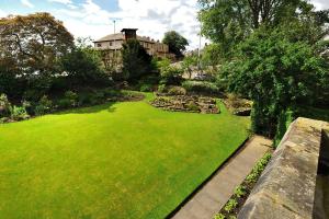 a green grassy area with a stone wall at St Michaels Guest House in Elgin