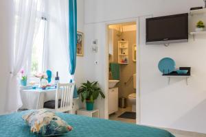 1 dormitorio con 1 cama y baño con mesa en Studio Elly, en Dubrovnik