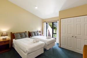 een slaapkamer met 2 bedden en een raam bij Amazing View Home in Queenstown