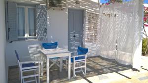 a white table and chairs on a patio at Paleochori Studios in Paliochori