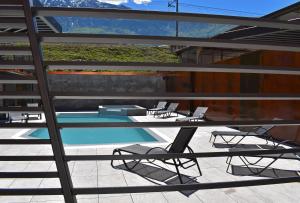a view of a pool with chairs and a table at Residence Lake Como in Colico