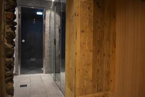 a glass shower in a bathroom with a wooden wall at Residence Lake Como in Colico