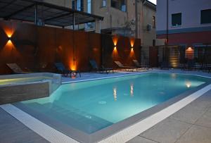 a swimming pool in a building with chairs around it at Residence Lake Como in Colico
