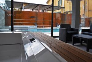 a swimming pool with a wooden table and chairs at Residence Lake Como in Colico