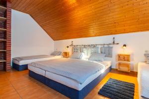 two beds in a bedroom with a wooden ceiling at Rodinné vinařství Turzík in Mutěnice