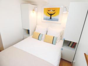 - une petite chambre avec un lit blanc et 2 oreillers dans l'établissement Le Pouffre, maison de pêcheur au quartier des artistes, clim, WiFi, à Sète
