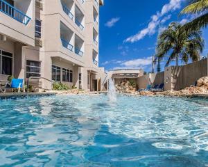 a swimming pool with a fountain in front of a building at Comfort Inn & Suites Levittown in Levittown