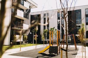um parque infantil vazio em frente a um edifício em Hypnotize Apartment em Konin