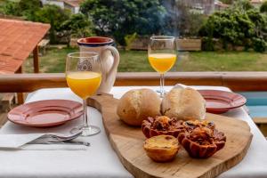 una mesa con dos vasos de zumo de naranja y comida en Terra Lodge, en Ericeira