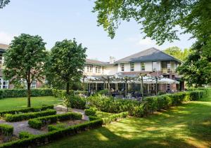 奥拉涅沃德Parkhotel Tjaarda的建筑前的花园