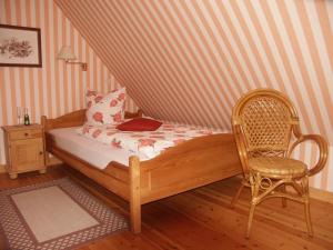 une chambre avec un lit avec une chaise et un ordinateur portable dans l'établissement Krohnprinzenhof Hotel Garni und Ferienwohnungen, à Fargau-Pratjau