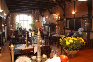 un restaurant avec des tables et des chaises avec des fleurs dessus dans l'établissement Krohnprinzenhof Hotel Garni und Ferienwohnungen, à Fargau-Pratjau 22 autres photos