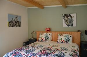 um quarto com uma cama e duas fotografias na parede em B & B Boezeneren em Yerseke