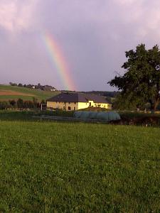 un arco iris en el cielo sobre un campo con una casa en Appartement St. Peter a Wimberg en Neufelden