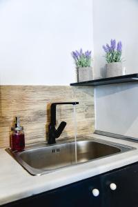 um lavatório de cozinha com uma torneira no balcão em Home Plus Psirri Apartment em Atenas