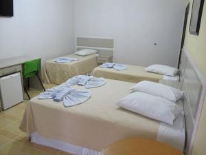 a room with two beds with towels on them at Hotel Piramide in Eldorado
