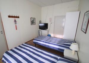 a small bedroom with two beds and a television at Käyrämön Keidas in Tiainen