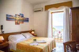 a bedroom with a bed with a view of the ocean at Hotel La Mandorla in Ischia