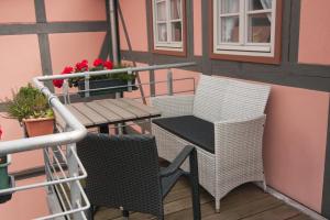 einen Balkon mit 2 Stühlen und einem Tisch mit Blumen in der Unterkunft Urlaub im Fachwerk - Klink in Quedlinburg