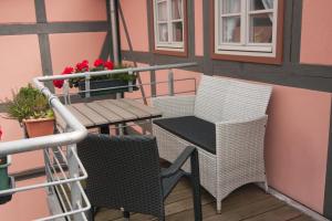 a balcony with two chairs and a table with flowers at Urlaub im Fachwerk - Klink in Quedlinburg