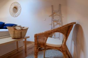 a wicker chair in a bedroom with a table and a mirror at Casas de Mértola 33 in Mértola
