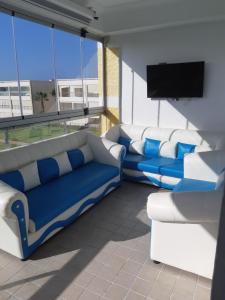 a living room with couches and a flat screen tv at Ola Blanca in Dar Hamida