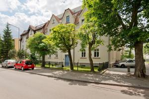 czerwony samochód zaparkowany przed domem w obiekcie Imperial Apartments - Balticana w mieście Sopot +5 zdjęć