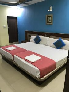 1 dormitorio con 1 cama grande y paredes azules en Highland Inn Hotel en Mangalore