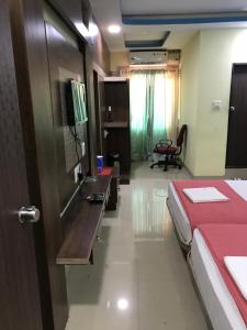 Habitación con cama, escritorio y mesa. en Highland Inn Hotel en Mangalore