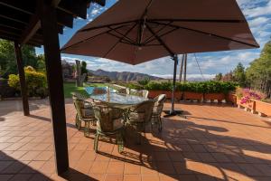 a table and chairs with an umbrella on a patio at Roque nublo rural houses I in Vega de San Mateo