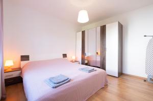 a bedroom with a white bed with two towels on it at Apartment Ksenija in Ljubljana