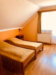 1 dormitorio con 2 camas y ventana en Horváth Vendégház, en Orosháza