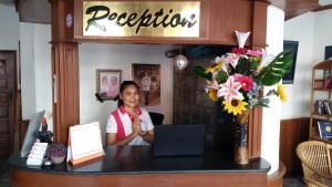 a woman sitting at a counter with a laptop at Orchid Residence in Patong Beach